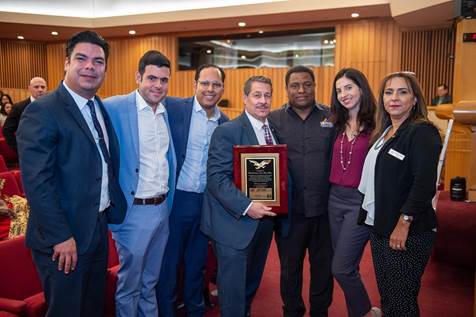 Commissioner Diaz accepts an award from Venezuelan-American activist Helen Villalonga and members of her organization Amevex.