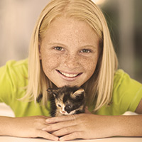 Young girl smiling with a kitten