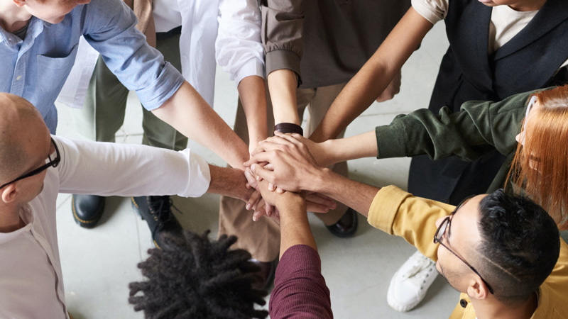 group of people doing an "all for one, one for all" style high-five