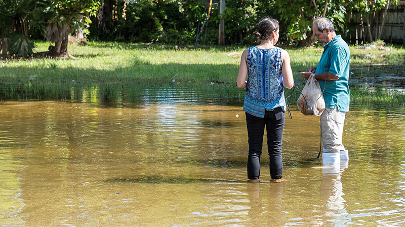 Two volunteers standing in a flood.