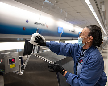 Person cleaning American Airlines ticket counter