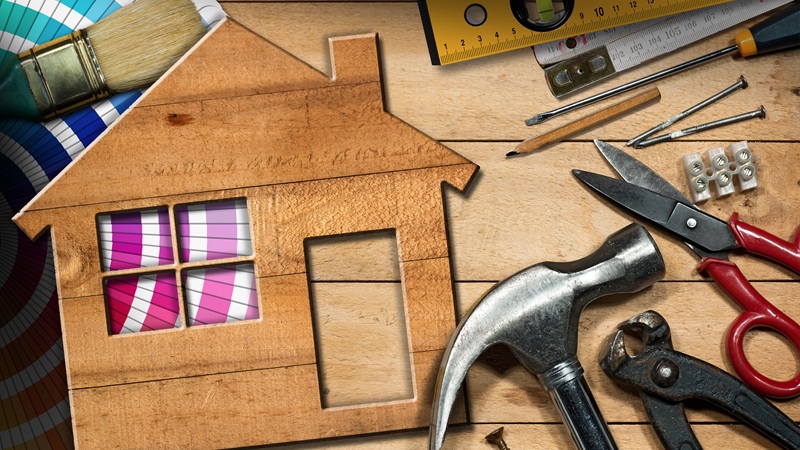 image of a home and numerous home improvement tools such as a hammer, pliers and scissors.