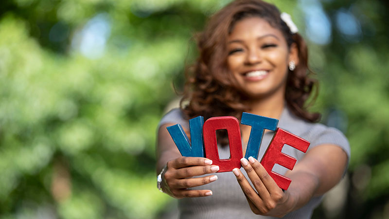 woman holding the word vote