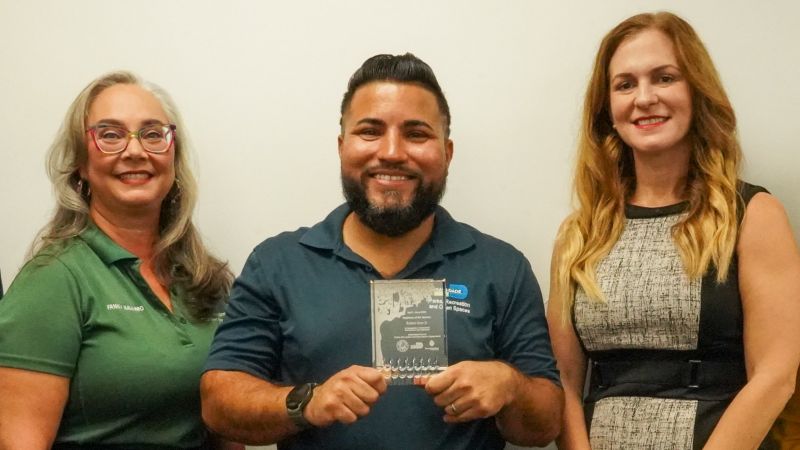 two women and a man smiling
