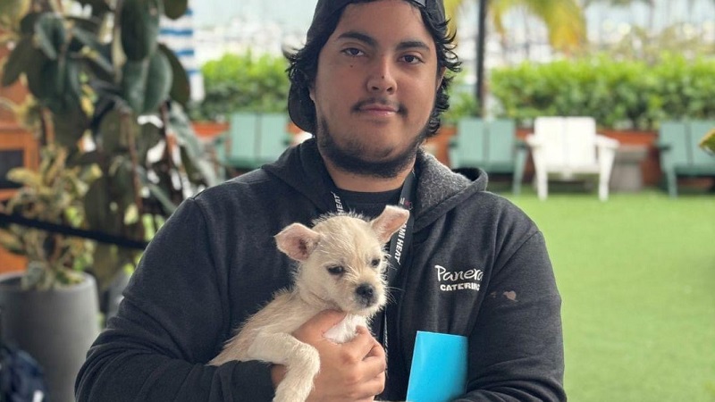 Young man holding recently adopted dog. 