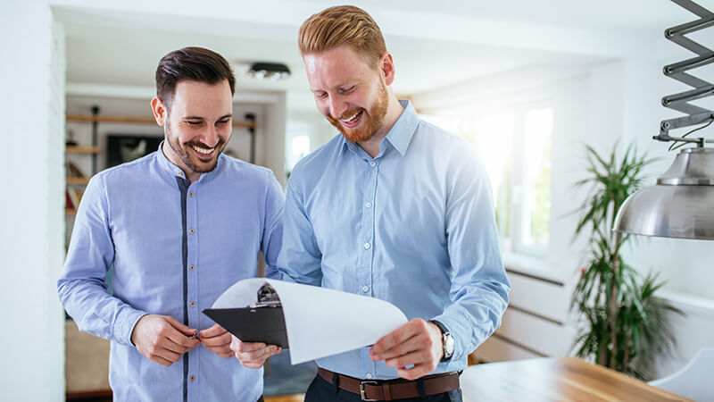 Two men looking at a document.