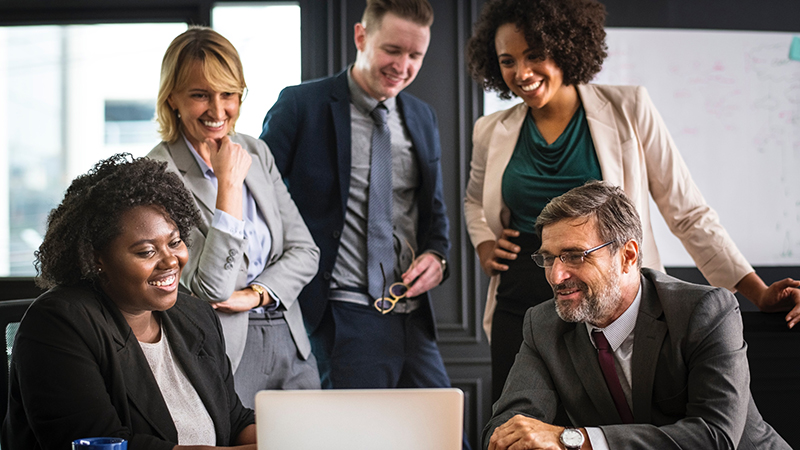 Diverse professionals looking at a laptop