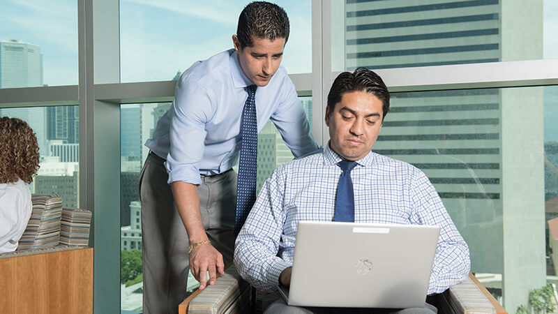 Two vendors going over items on a laptop computer