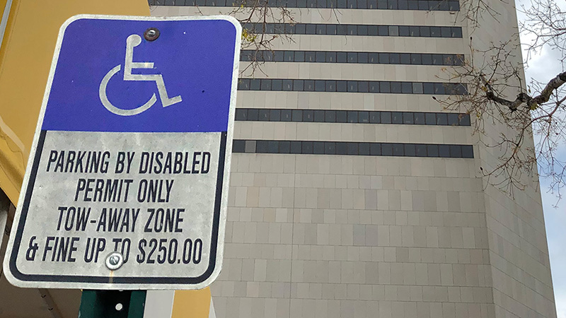 Handicapped parking sign with Stephen P. Clark Center in the background