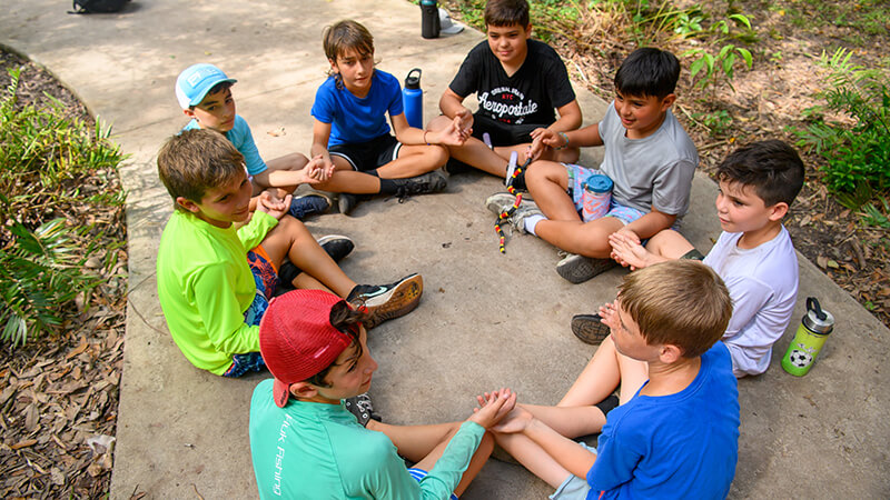 A group of Camp Owaissa Bauer campers sitting in a circle.