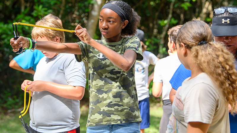 Camp Owaissa Bauer campers using slingshots.