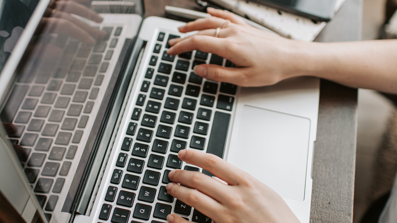 hands typing on a laptop