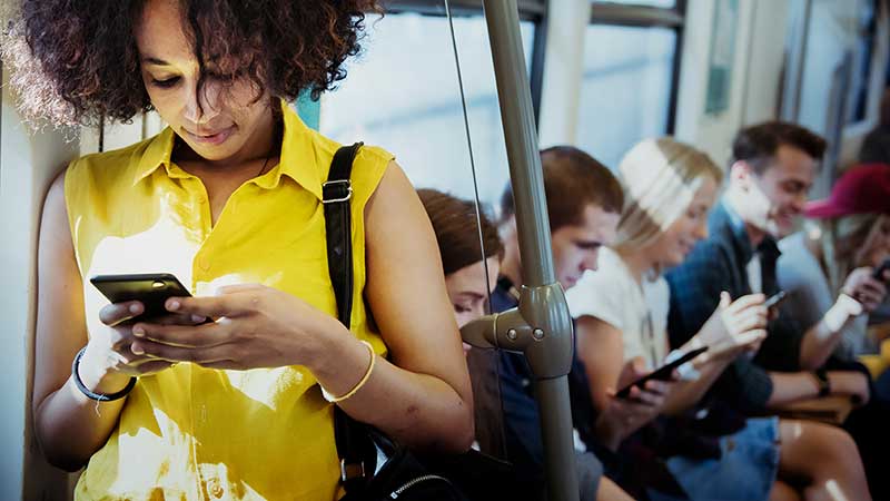 Young woman checking her phone on the train