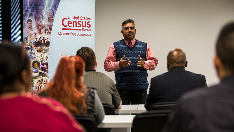 Man giving a presentation before a group of people.