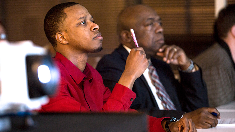 Two men sitting in a training classroom.