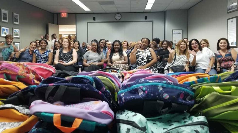 The ISD team photographed with the 60 bookbags donated to students in need