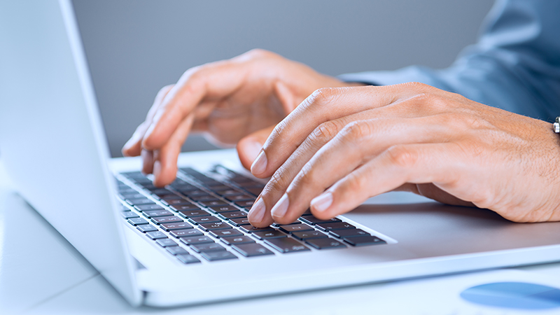 hands typing on a laptop