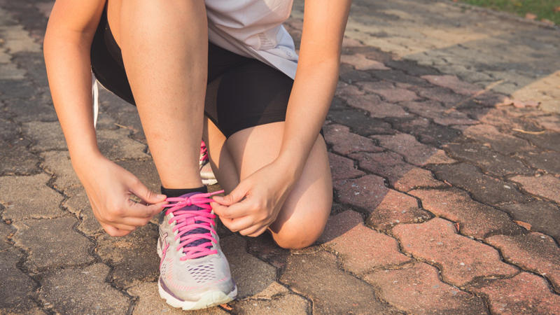 woman tying shoe laces.