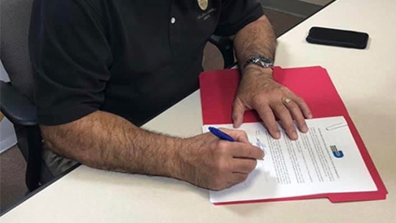 The Mayor signs the executive order.