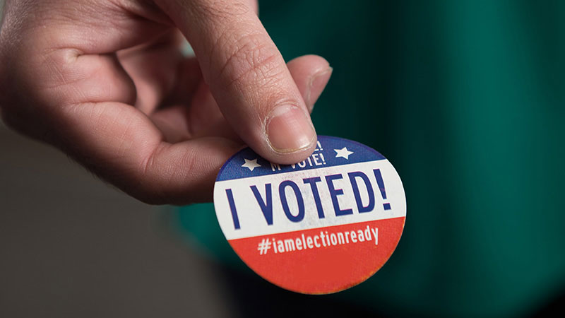 Man with an I VOTE sticker on his shirt