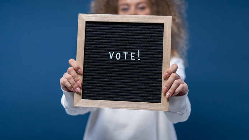 Woman holding sign that reads "Vote"