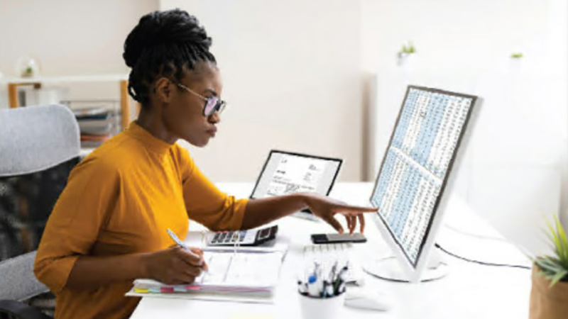 Woman sitting at a desk looking at a laptop