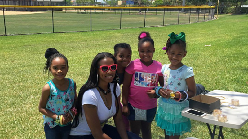 Officer Citia Easterling crouching next to four young girls