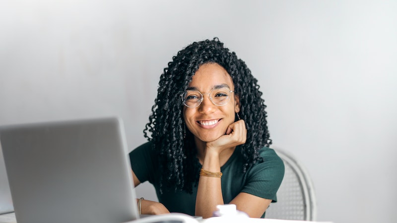 Woman smiling in front of open laptop