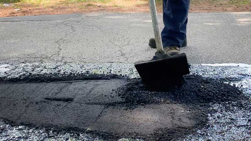 person filling a pothole