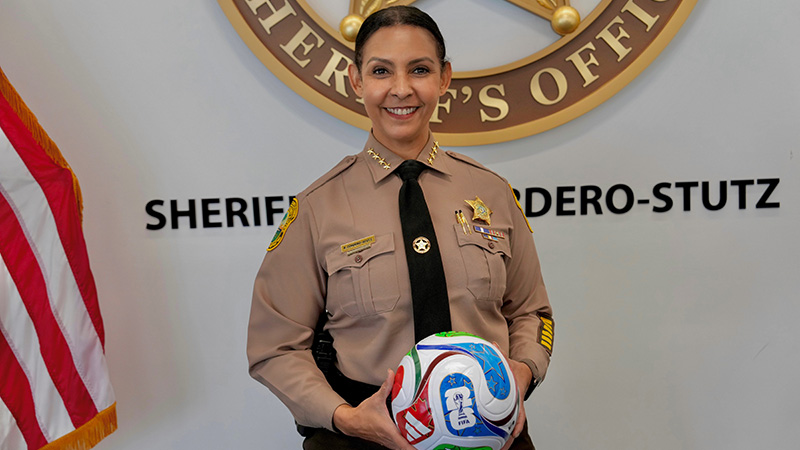 Miami-Dade Sheriff Rosie in uniform holding a FIFA World Cup soccer ball.