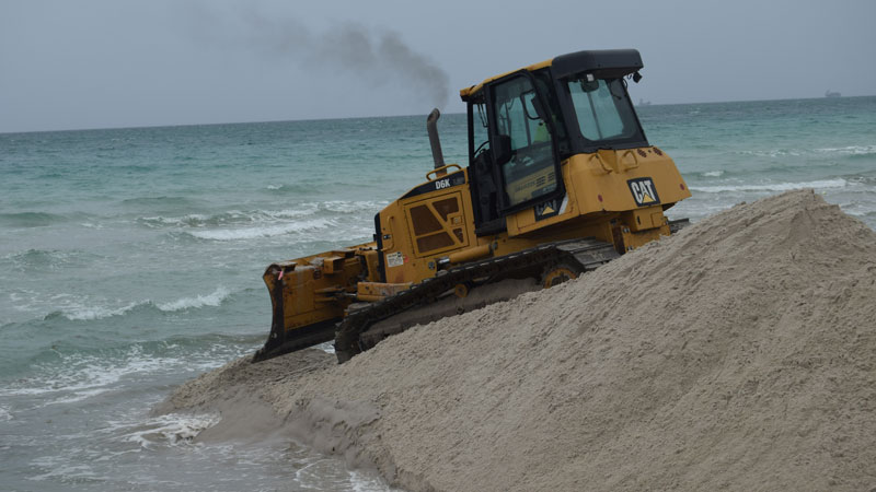 a bulldozer by the shore on the beach