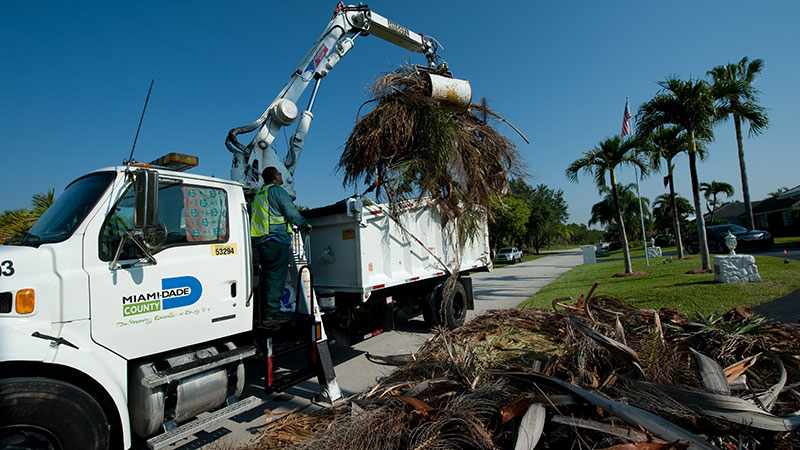 Solid waste truck picking up debris. 