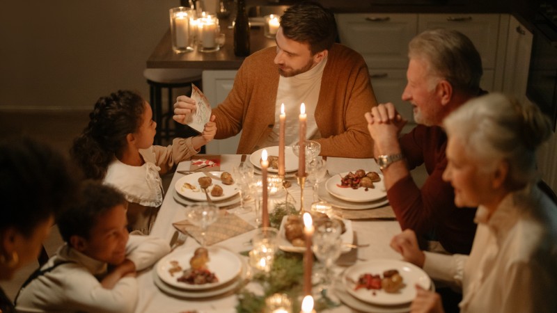 Photo of family dinning by candle light