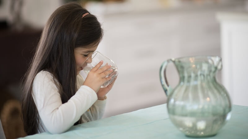 Young girl drinking tap water