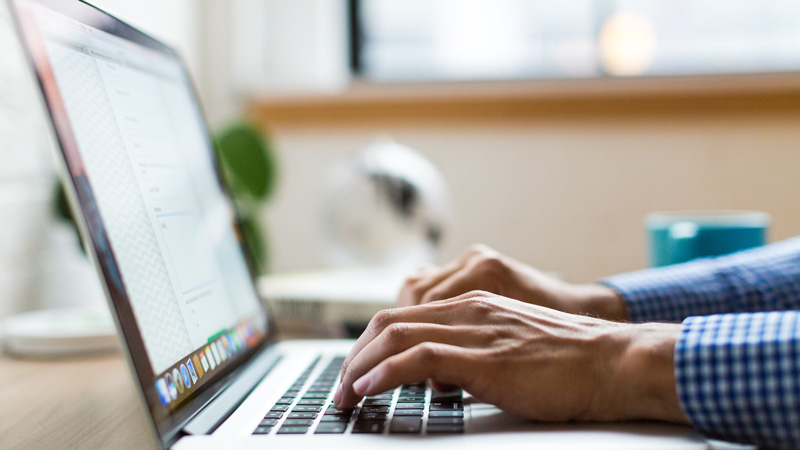 Close up photo of person’s hands over laptop’s keyboard