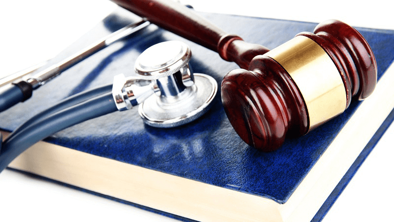 A stethoscope and gavel placed on top of a book.