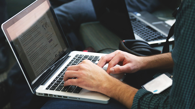 Hands of person typing on a laptop computer