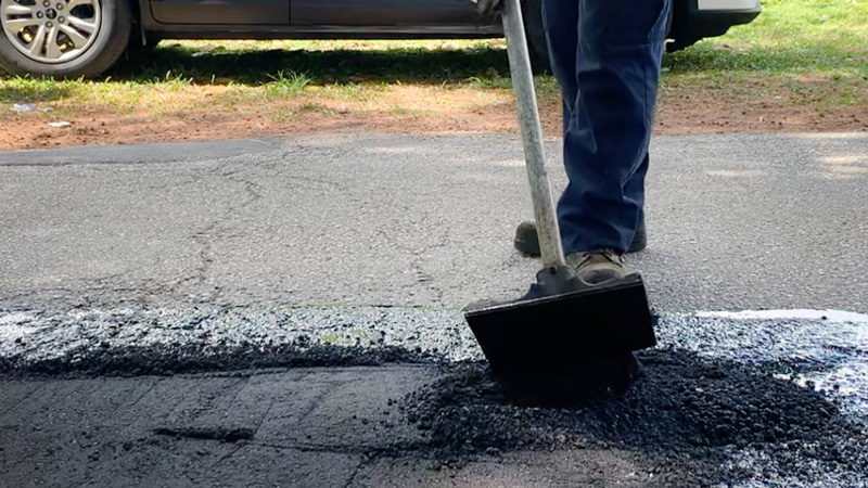 person filling a pothole