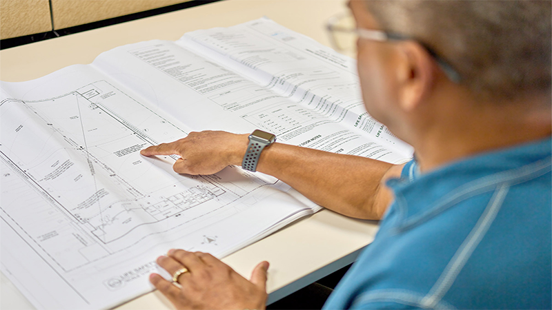 A man pointing at at a blueprint