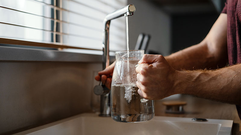 Pitcher being filled with tap water 