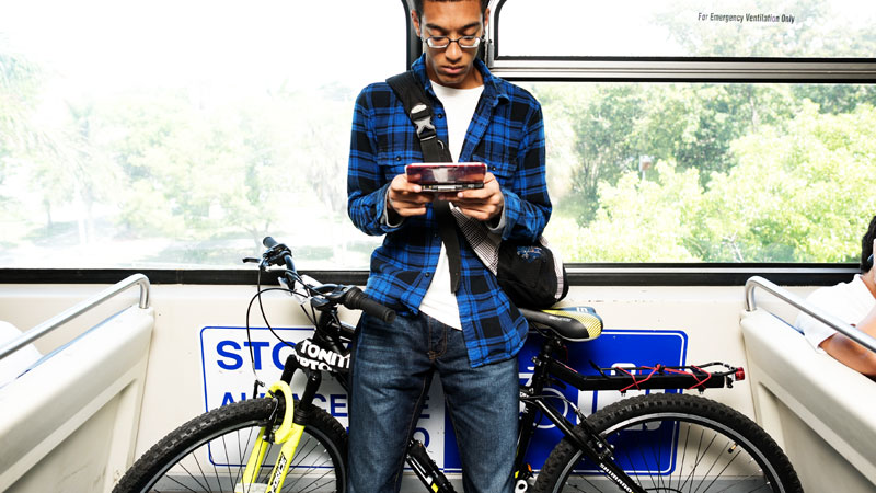 young boy riding transit with his bike
