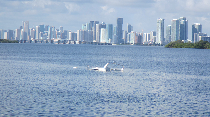 sunken powerboat almost entirely submerged in Biscayne Bay