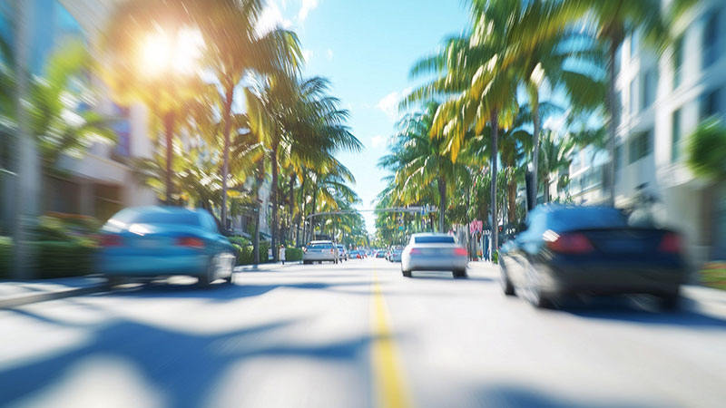 a street with cars and palm trees, ai generated