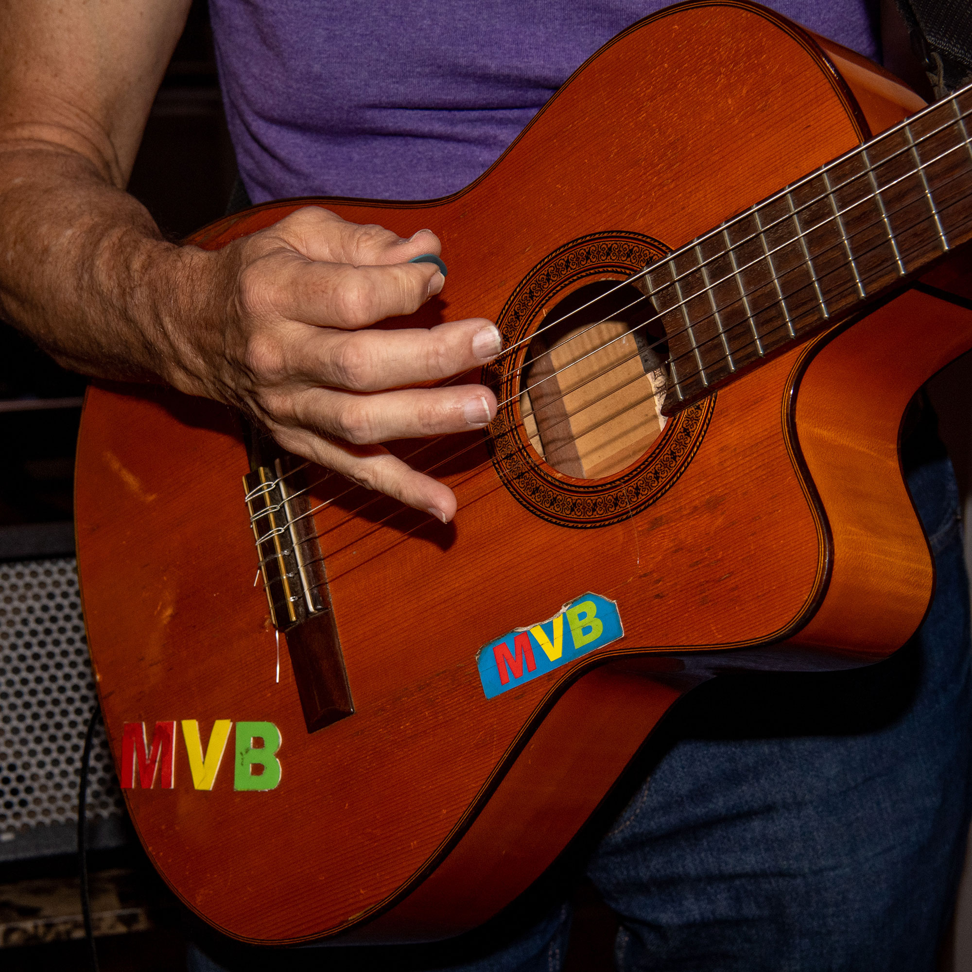 a man's hand strumming a guitar