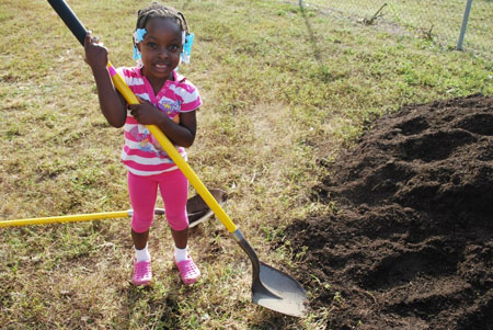 A young volunteer at a Health in the Hood Community Garden.